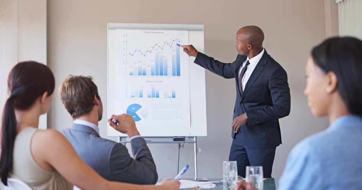 man pointing at presentation infront of investors